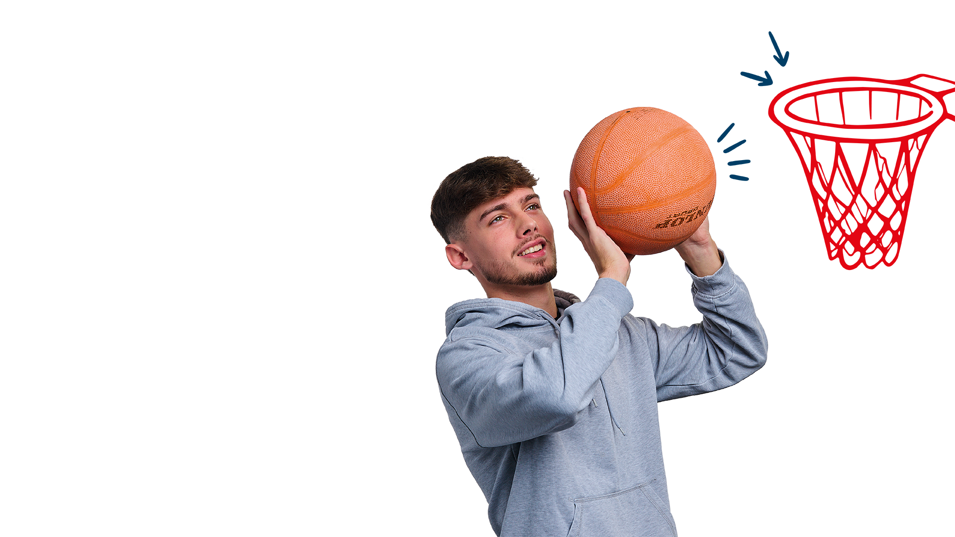 Junger Mann mit braunem, kurzem Haar und Bart trägt einen grauen Hoodie und hält einen Basketball in beiden Händen. Er blickt fokussiert nach oben, als ob er gleich werfen würde.