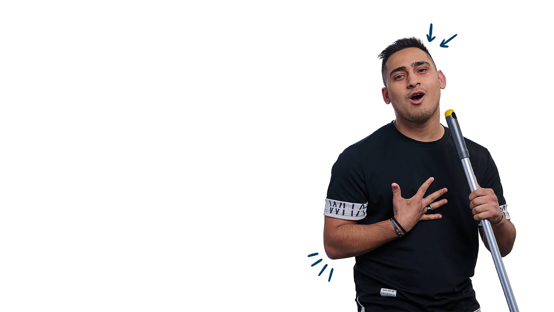 Junger Mann mit kurzem, dunklem Haar trägt ein schwarzes T-Shirt mit weißem Schriftzug auf den Ärmeln. Er hält einen Blindenstock in der einen Hand und berührt mit der anderen seine Brust, während er mit ausdrucksstarkem Gesichtsausdruck spricht oder singt.